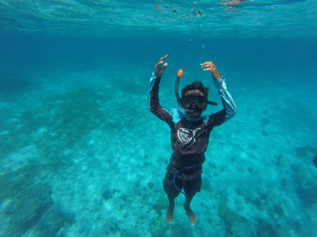 Noveno is snorkeling in wonderful blue water